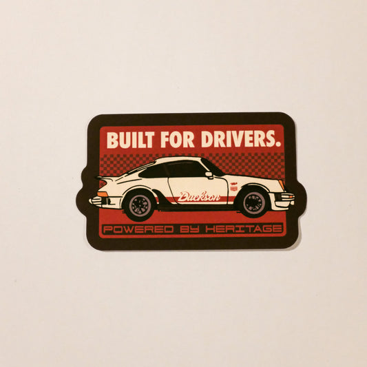 Sticker with a car design and text 'Built for Drivers' on a beige background