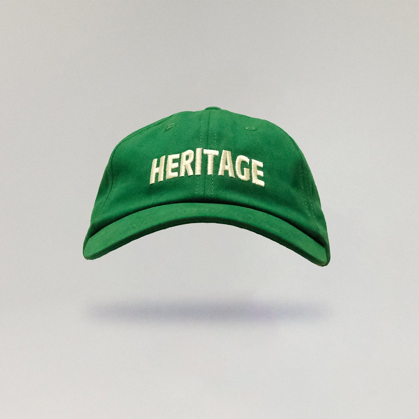 Green cap with 'HERITAGE' text on a gray background
