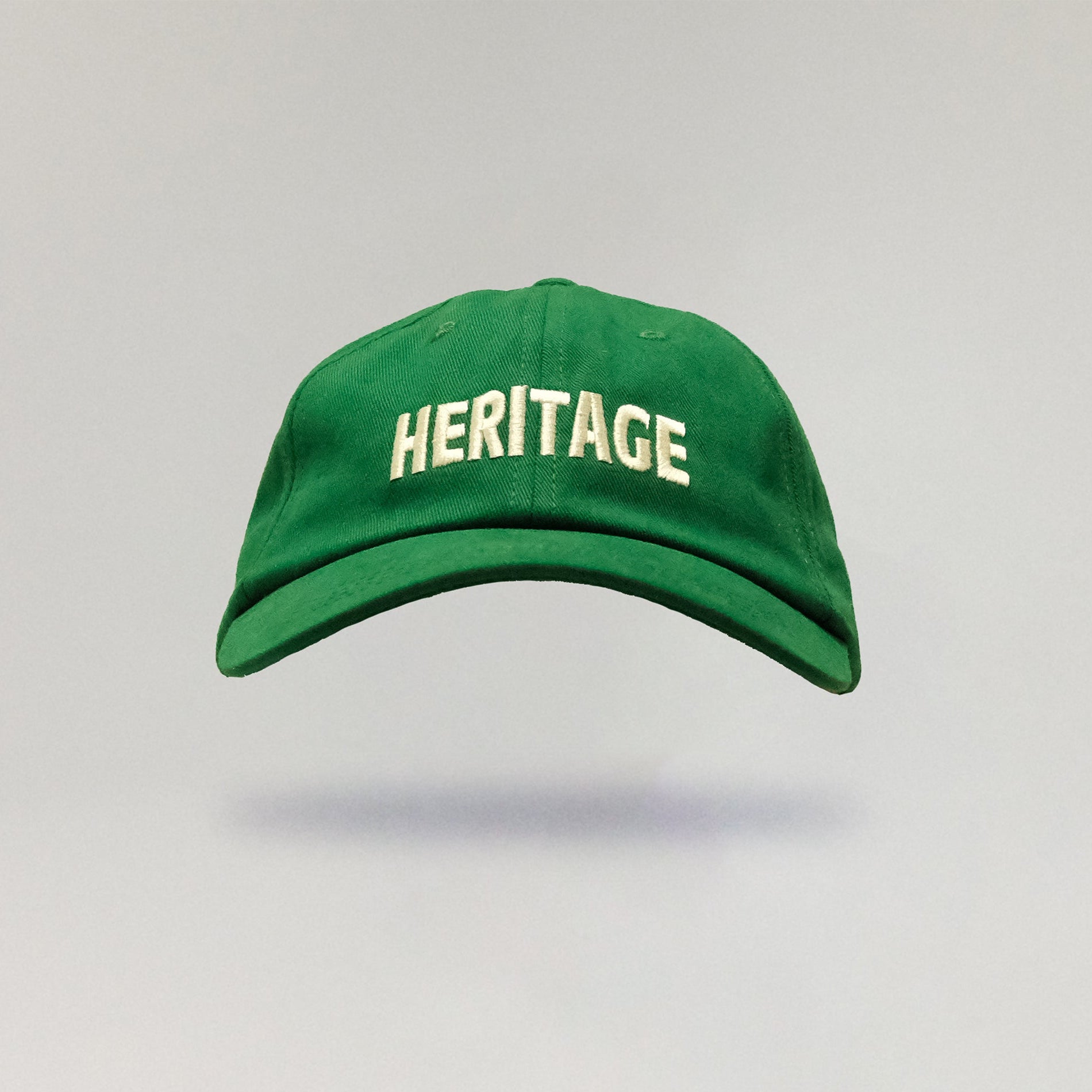 Green cap with 'HERITAGE' text on a gray background